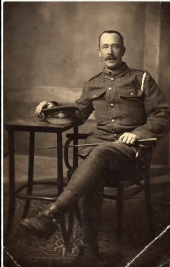 George Henry Gates seated in uniform beside a table with his service cap